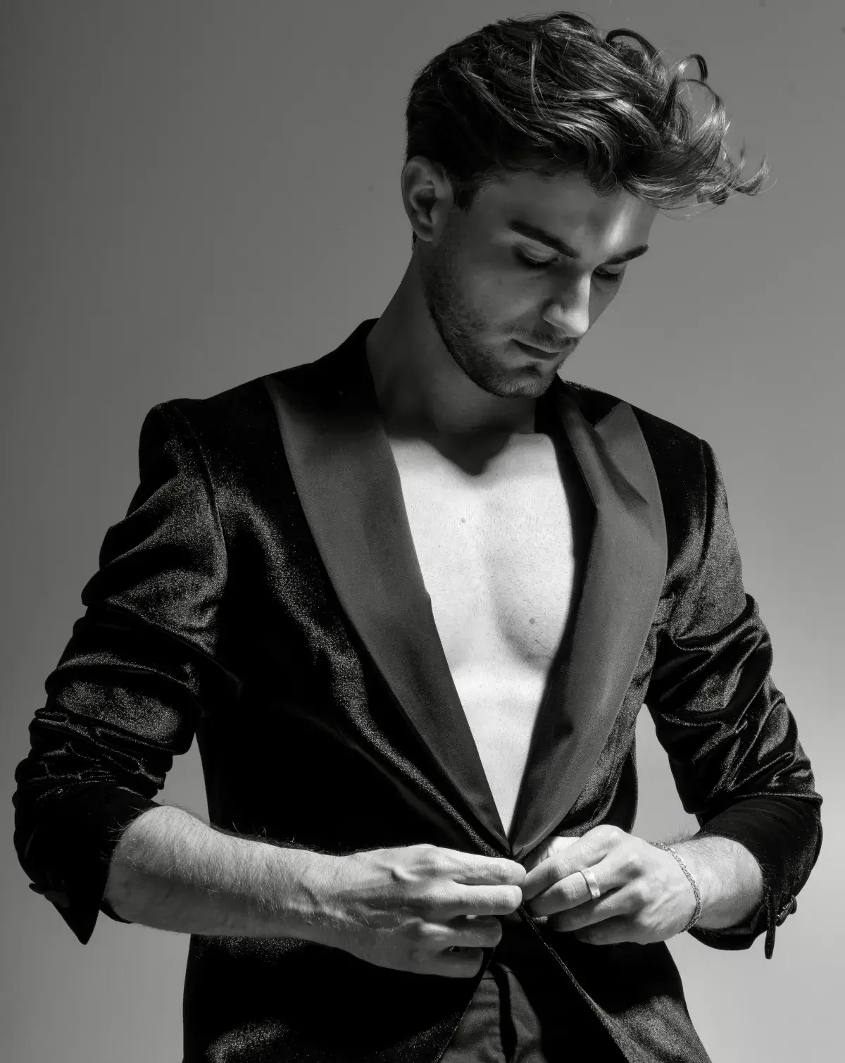 Model im beigen Anzug posiert vor neutralem Hintergrund