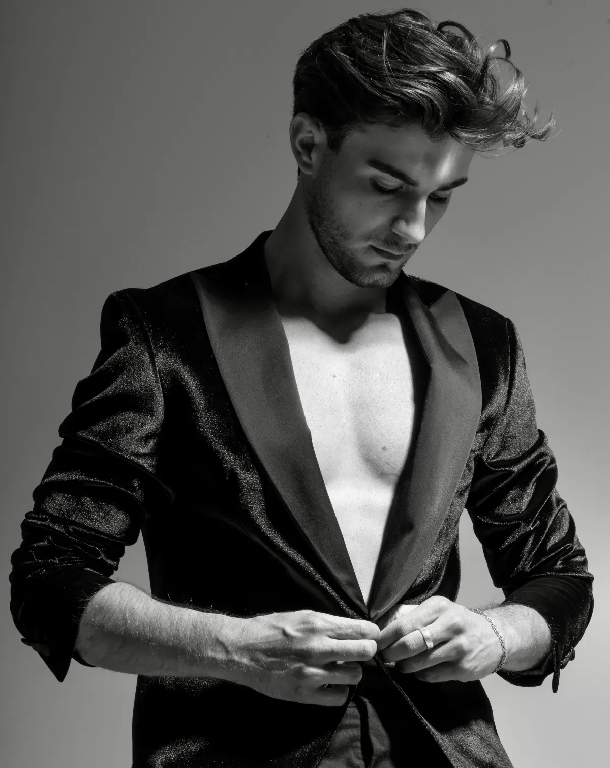 Model im beigen Anzug posiert vor neutralem Hintergrund